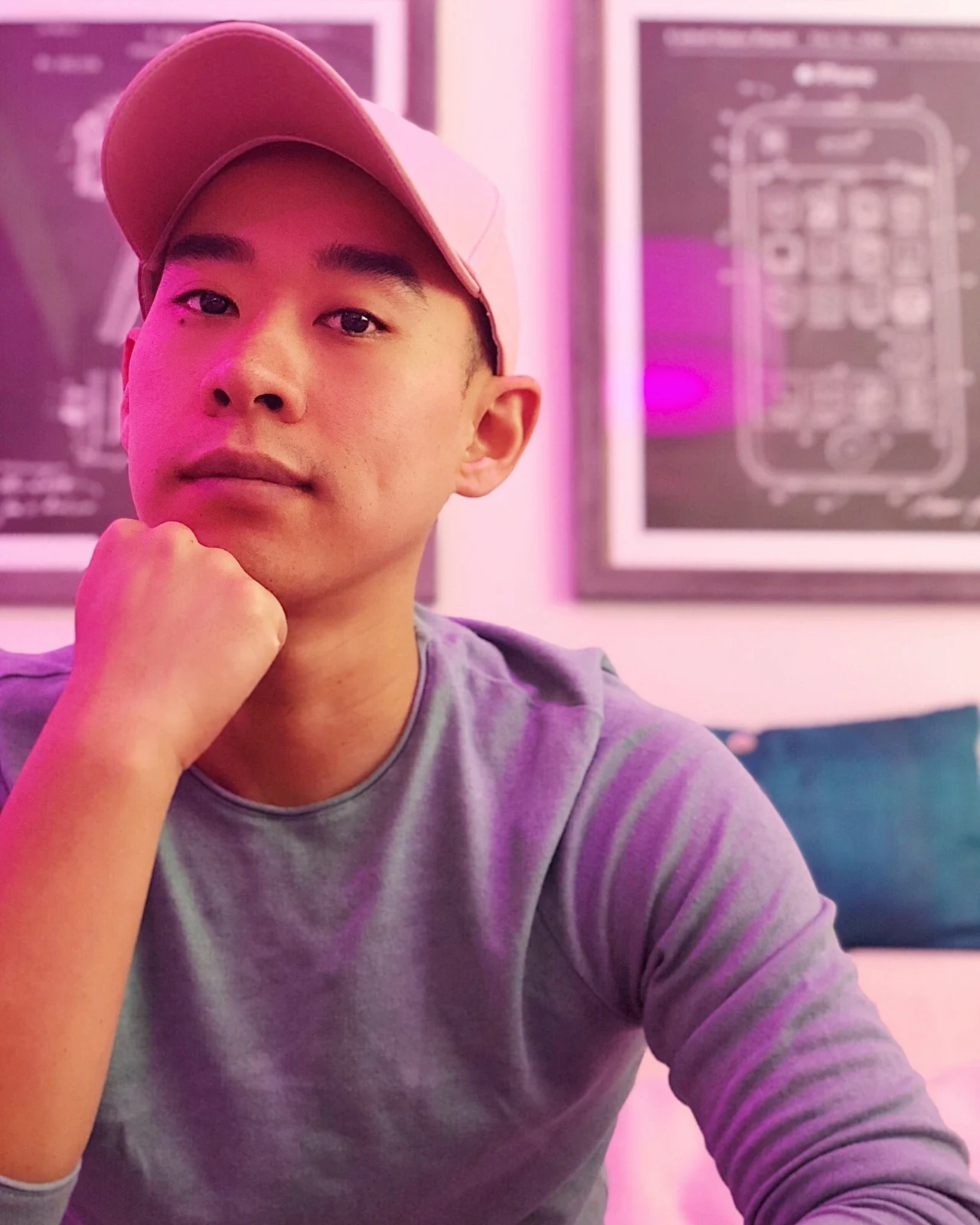 Kane in a pink cap, photographed under pink and violet lighting