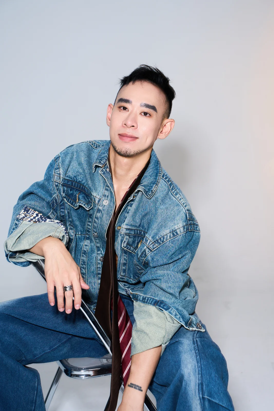 Kane in a denim jacket seated in a studio